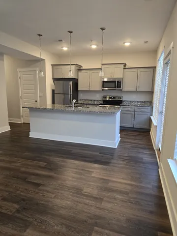 a kitchen with kitchen island a counter top space a stove and cabinets