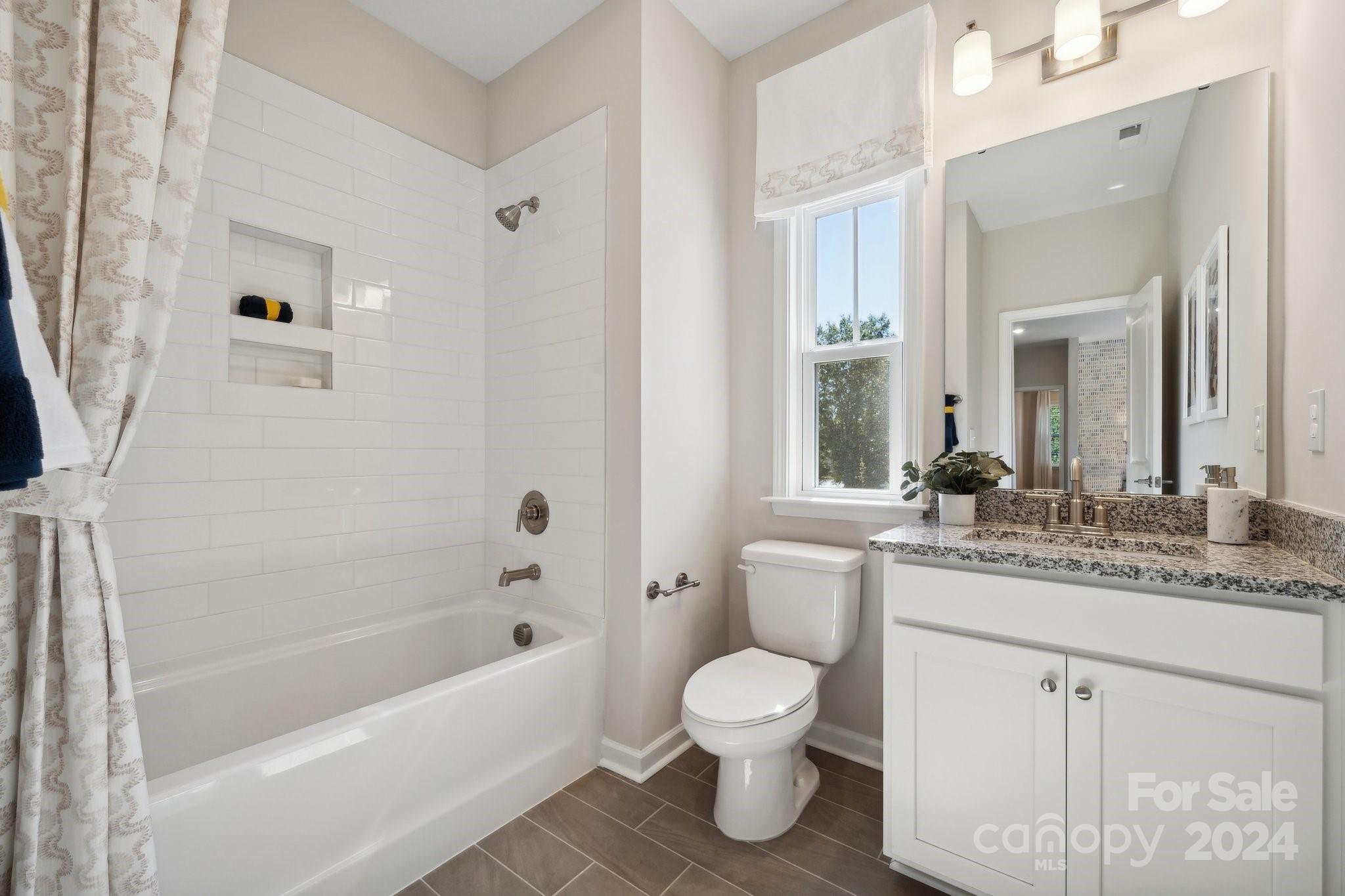1410 Hubert Graham Way Tega Cay, SC 29708 - Photo 23 of 28 a bathroom with a granite countertop sink toilet and shower
