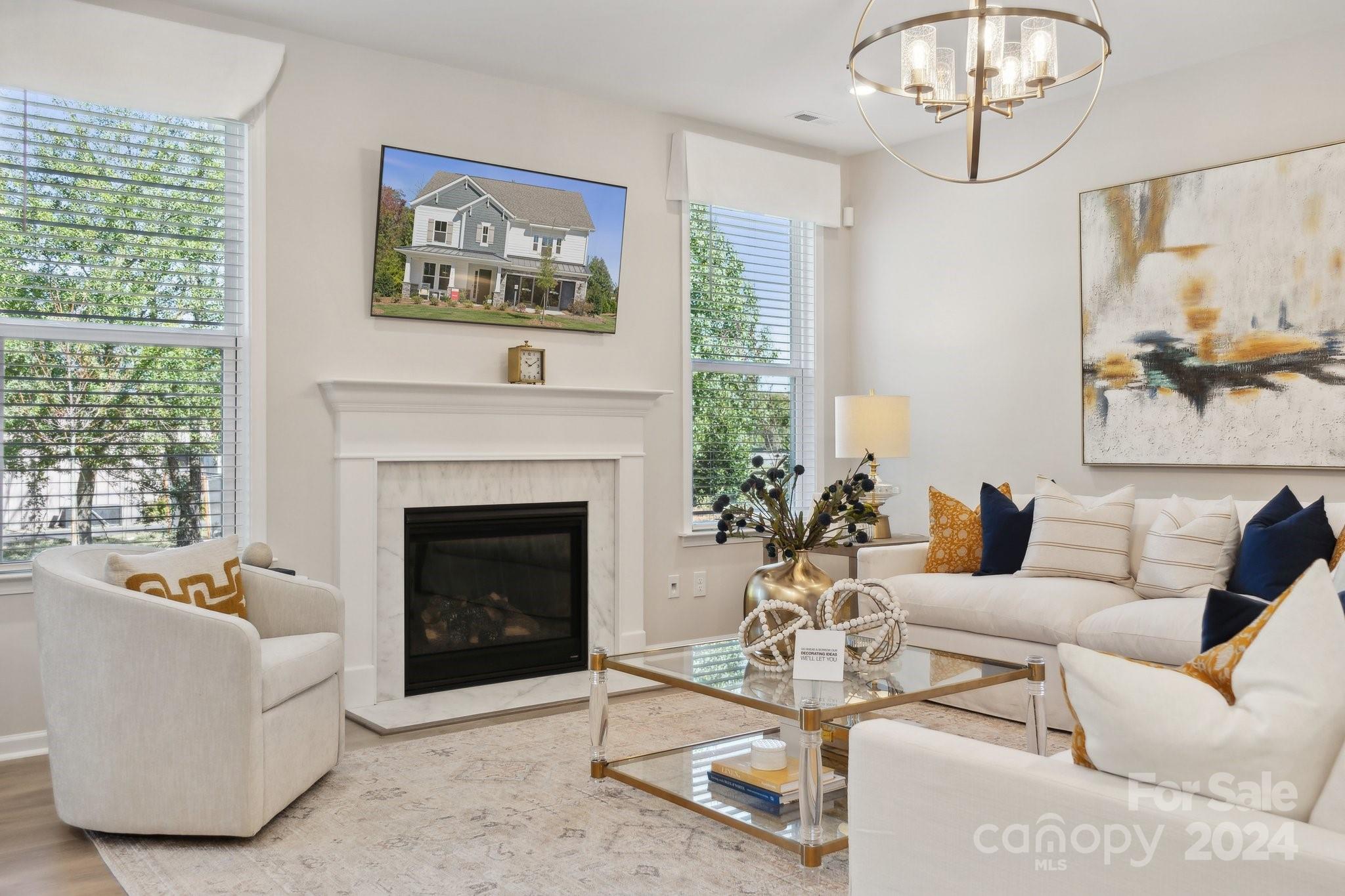 1410 Hubert Graham Way Tega Cay, SC 29708 - Photo 6 of 28 a living room with furniture a chandelier and a fireplace