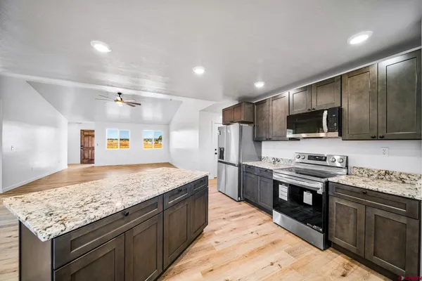 a large kitchen with stainless steel appliances kitchen island a large counter top and a sink