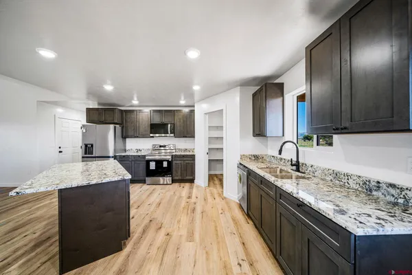 a large kitchen with kitchen island a sink stainless steel appliances and cabinets