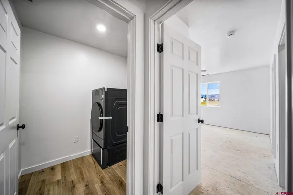 a view of a hallway with wooden floor and closet area