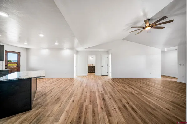 a view of a kitchen with wooden floor and a ceiling fan