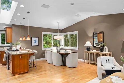 a living room with furniture a large window and kitchen view