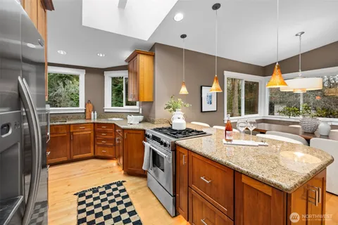 a kitchen with stainless steel appliances granite countertop a sink stove and refrigerator