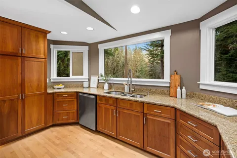 a kitchen with stainless steel appliances granite countertop a sink and large window