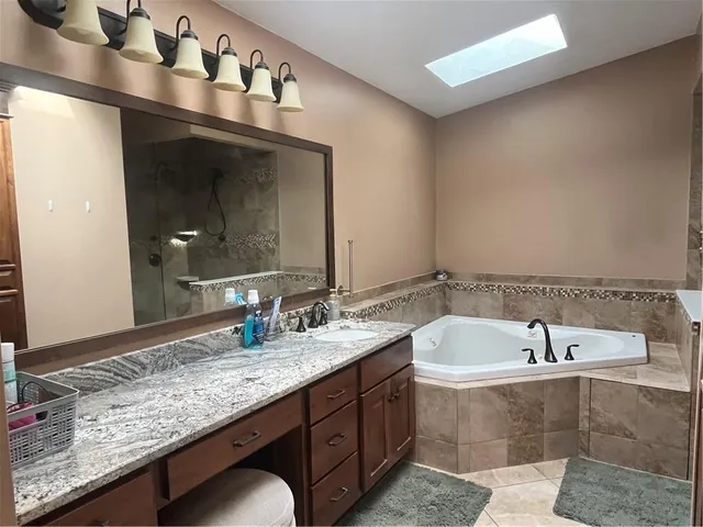 a bathroom with a bathtub and double sink