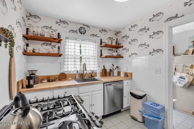 a kitchen with stainless steel appliances a sink a stove and a refrigerator