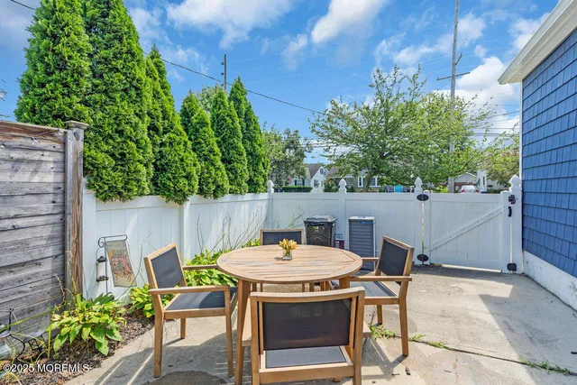 a backyard of a house with table and chairs with plants