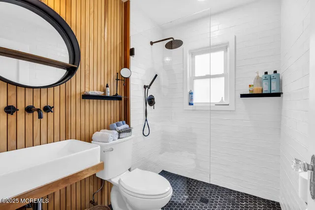 a bathroom with a sink a toilet and a mirror