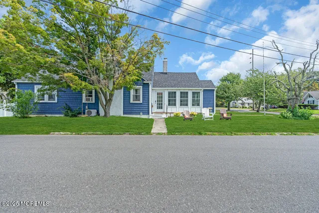 a view of a house with a big yard and large trees