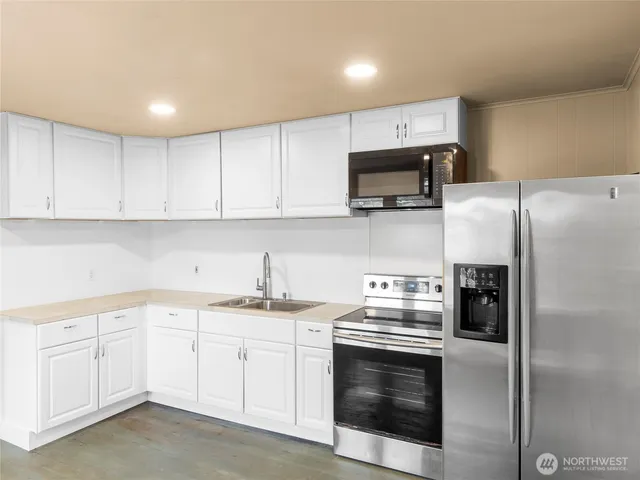 a kitchen with white cabinets and stainless steel appliances