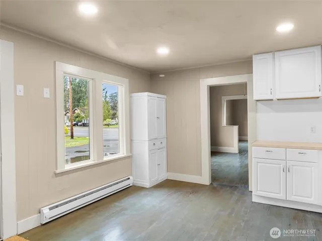 an empty room with windows and cabinet