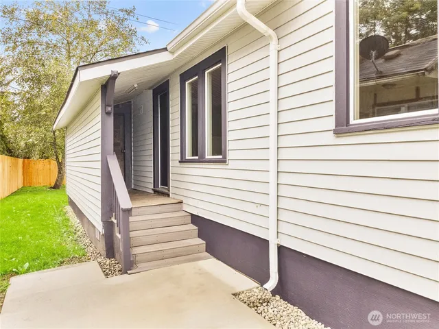 a view of a house with a backyard and a tree