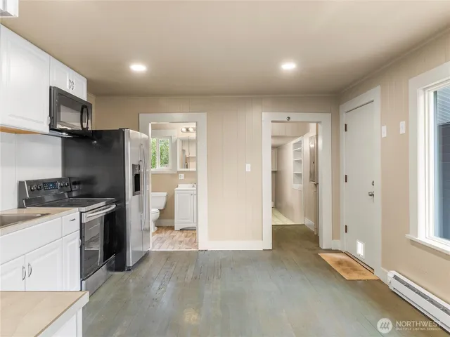 a view of a kitchen with a sink refrigerator and wooden floor