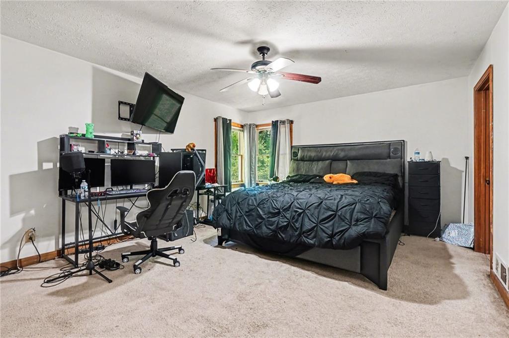 2530 Rockbridge Road Northwest Conyers, GA 30012 - Photo 33 of 45 a bedroom with a bed a chair and a chandelier