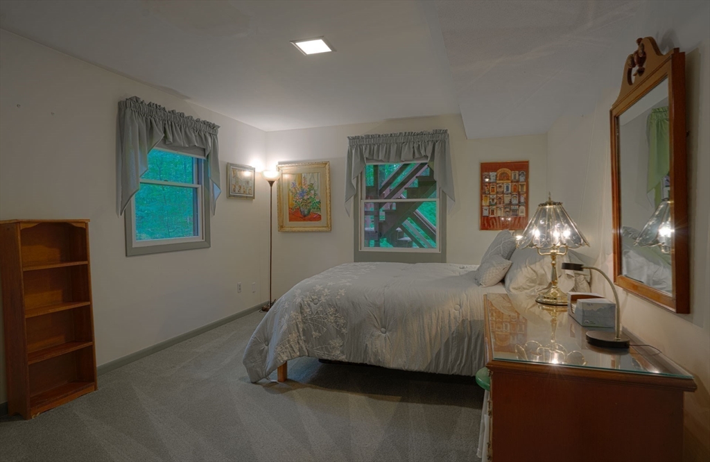 17 Juniper Lane Amherst, MA 01002 - Photo 34 of 42 a bedroom with a bed and a chandelier