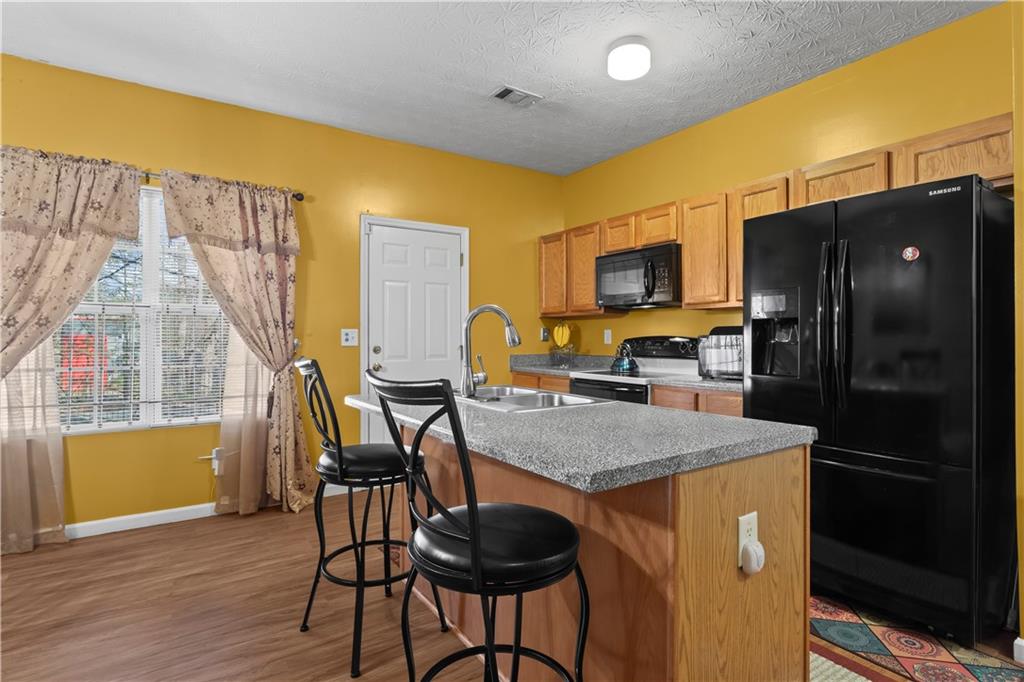 3000 Western Sunset Decatur, GA 30034 - Photo 13 of 37 a kitchen with stainless steel appliances granite countertop a refrigerator a stove top oven a sink dishwasher and dining table with wooden floor
