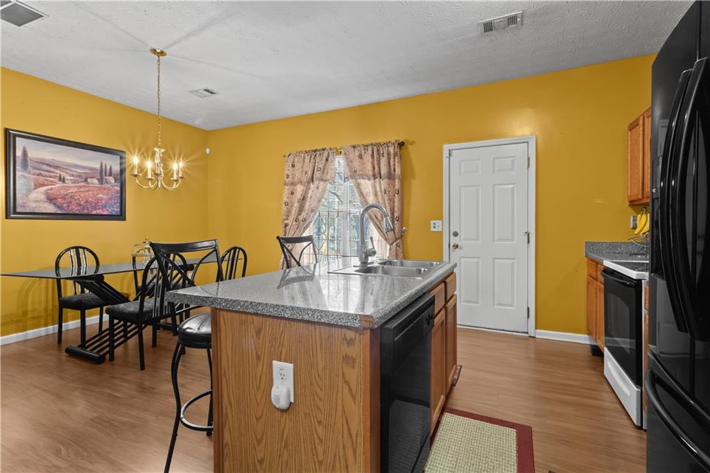 3000 Western Sunset Decatur, GA 30034 - Photo 15 of 37 a kitchen with stainless steel appliances granite countertop a stove a refrigerator a dining table and chairs with wooden floor
