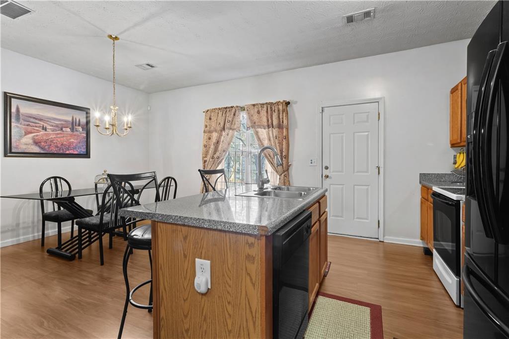 3000 Western Sunset Decatur, GA 30034 - Photo 16 of 37 a kitchen with stainless steel appliances granite countertop a stove top oven a sink a dining table and chairs with wooden floor