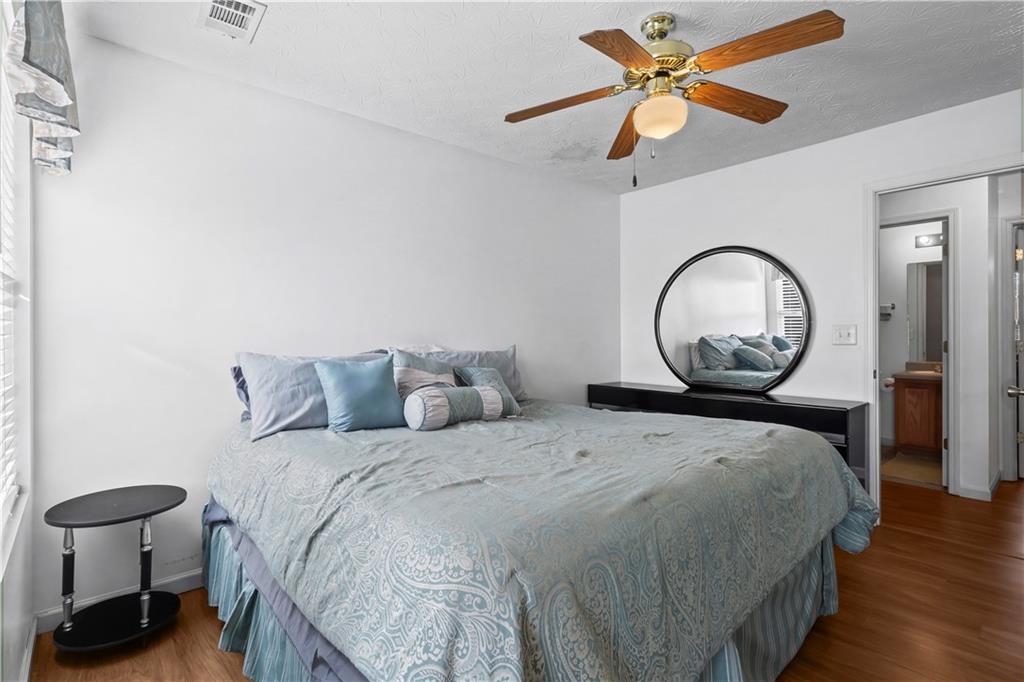 3000 Western Sunset Decatur, GA 30034 - Photo 22 of 37 a bedroom with a bed a clock on dresser and a chandelier