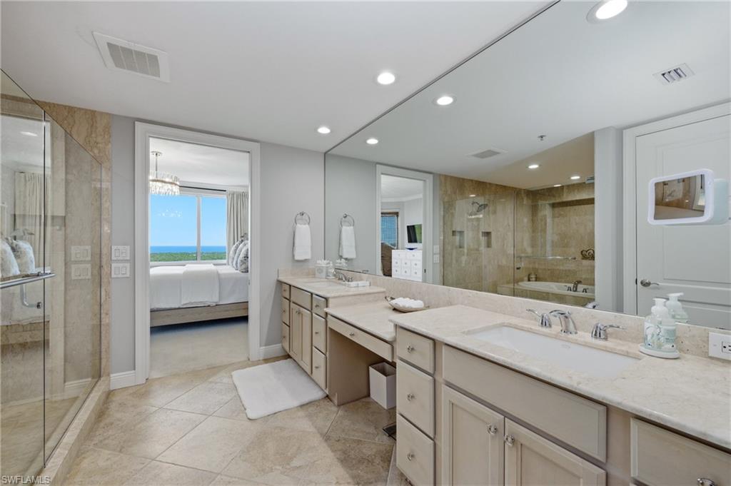 265 Indies Way, Unit 1004 Naples, FL 34110 - Photo 16 of 34 a spacious bathroom with a granite countertop sink mirror and shower