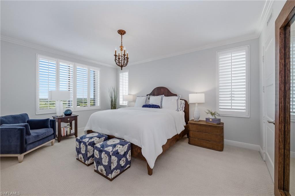 265 Indies Way, Unit 1004 Naples, FL 34110 - Photo 17 of 34 a bedroom with a bed and a couch next to a window