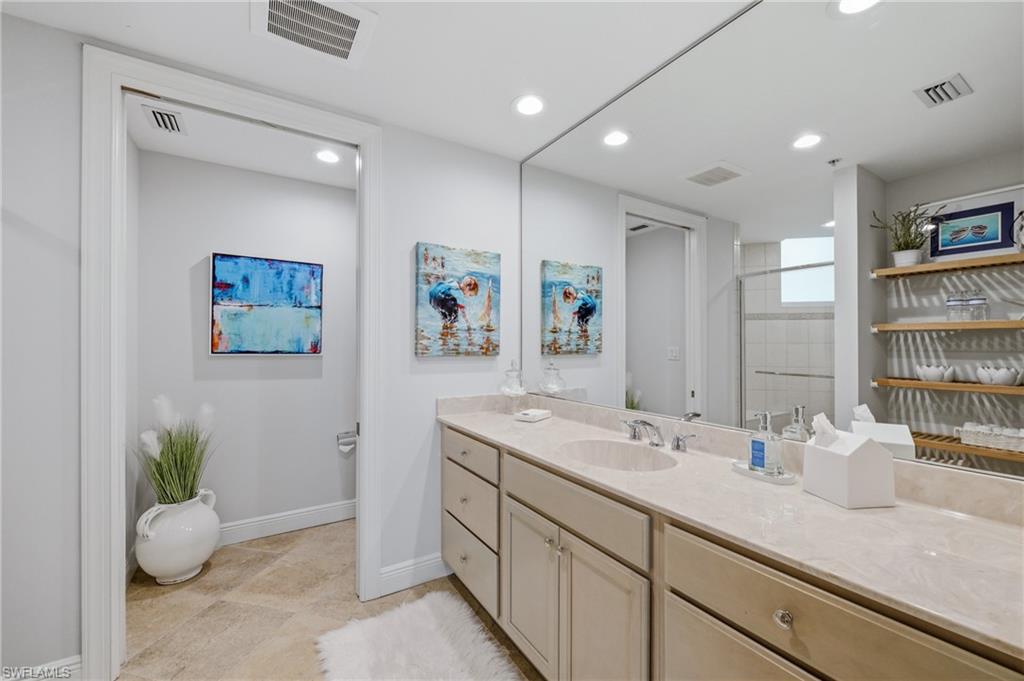 265 Indies Way, Unit 1004 Naples, FL 34110 - Photo 18 of 34 a bathroom with a sink a large mirror and vanity