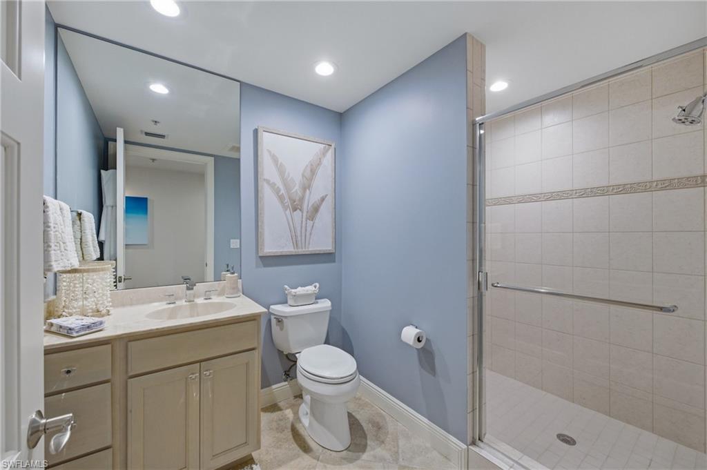 265 Indies Way, Unit 1004 Naples, FL 34110 - Photo 20 of 34 a bathroom with a granite countertop sink a toilet and shower