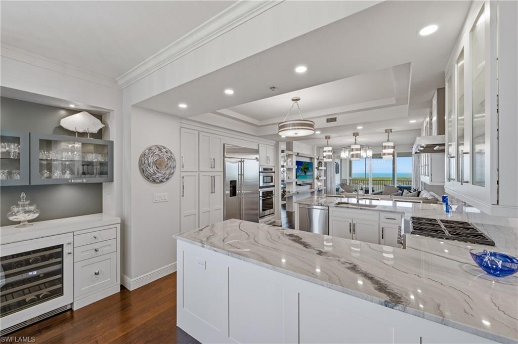 265 Indies Way, Unit 1004 Naples, FL 34110 - Photo 3 of 34 a kitchen with lots of counter top space and wooden floor