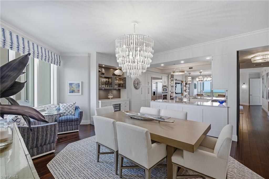 265 Indies Way, Unit 1004 Naples, FL 34110 - Photo 7 of 34 a dining room with furniture a chandelier and wooden floor