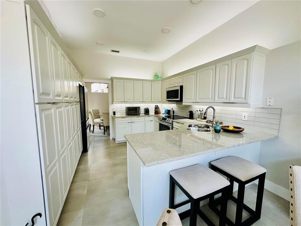 784 South Pennsylvania Avenue Winter Park, FL 32789 - Photo 11 of 29 a kitchen with sink refrigerator dining table and chairs