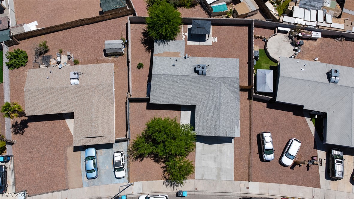 2870 South Sandhill Road Las Vegas, NV 89121 - Photo 58 of 64 An aerial perspective reveals the residential properties and surrounding xeriscape, featuring paved driveways and fenced yards.