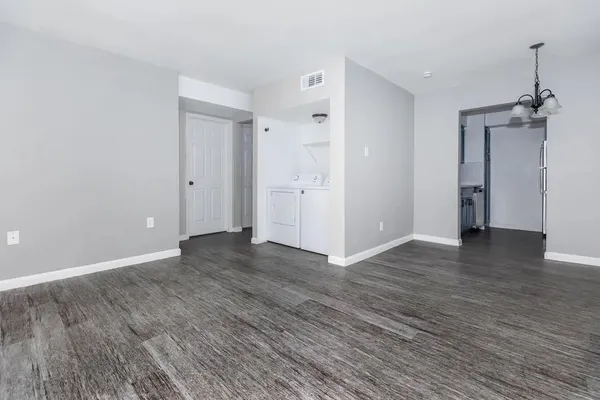 an empty room with wooden floor fireplace and windows