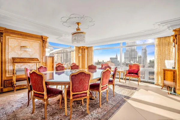 a view of a dining room and livingroom with furniture wooden floor a chandelier