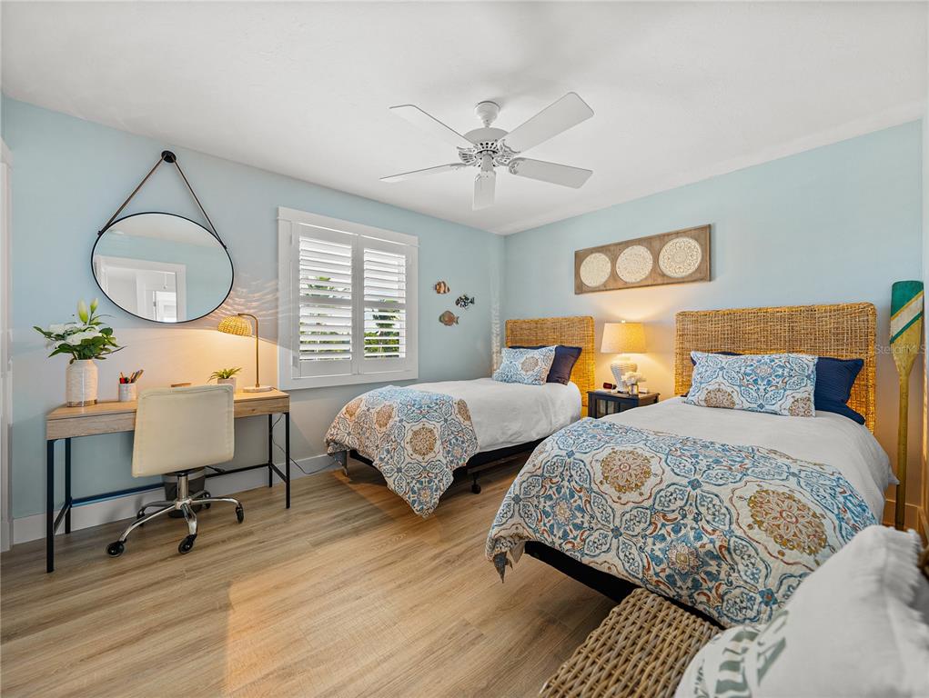 420 Gulf Boulevard, Unit 4 Boca Grande, FL 33921 - Photo 23 of 40 a bedroom with two beds and a chandelier
