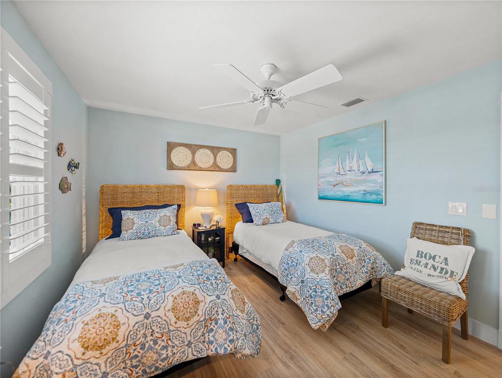 420 Gulf Boulevard, Unit 4 Boca Grande, FL 33921 - Photo 25 of 40 a bedroom with two beds and painting on the wall