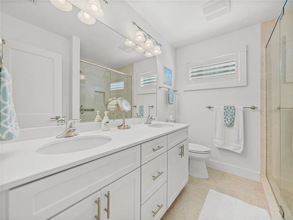 420 Gulf Boulevard, Unit 4 Boca Grande, FL 33921 - Photo 32 of 40 a bathroom with a double vanity sink toilet and shower