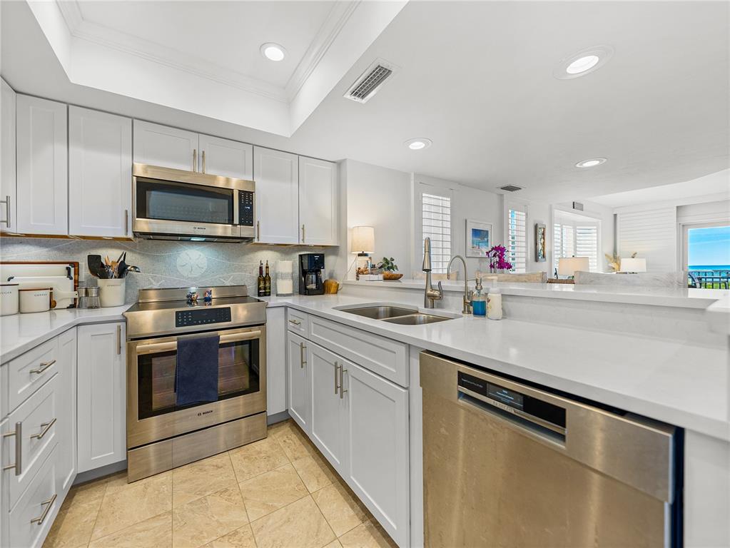 420 Gulf Boulevard, Unit 4 Boca Grande, FL 33921 - Photo 4 of 40 a kitchen with stainless steel appliances granite countertop a sink and a stove
