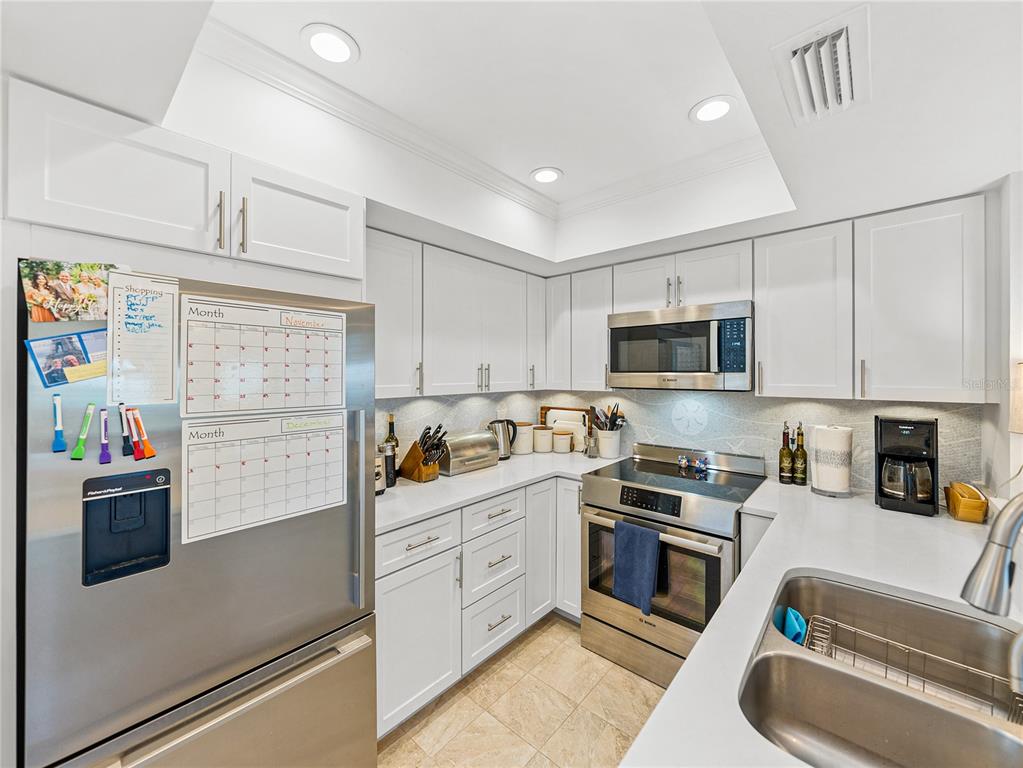 420 Gulf Boulevard, Unit 4 Boca Grande, FL 33921 - Photo 8 of 40 a kitchen with stainless steel appliances granite countertop a refrigerator and microwave