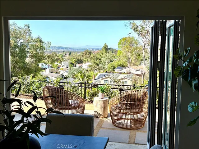 a view of a balcony with chairs and a potted plant
