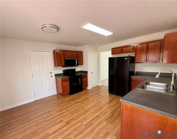 a kitchen with stainless steel appliances granite countertop a refrigerator a stove and a wooden floors