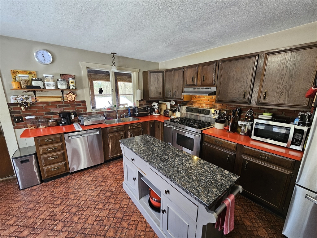 127 Summer Street Thorndike, MA 01079 - Photo 12 of 27 a kitchen with stainless steel appliances granite countertop a stove a sink dishwasher and cabinets with wooden floor