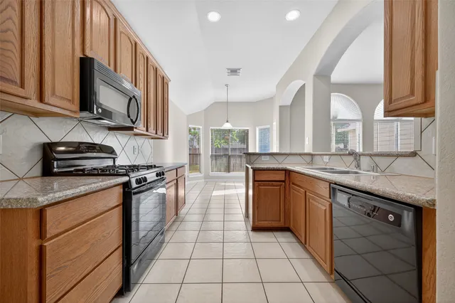 a kitchen with stainless steel appliances granite countertop a sink and a stove