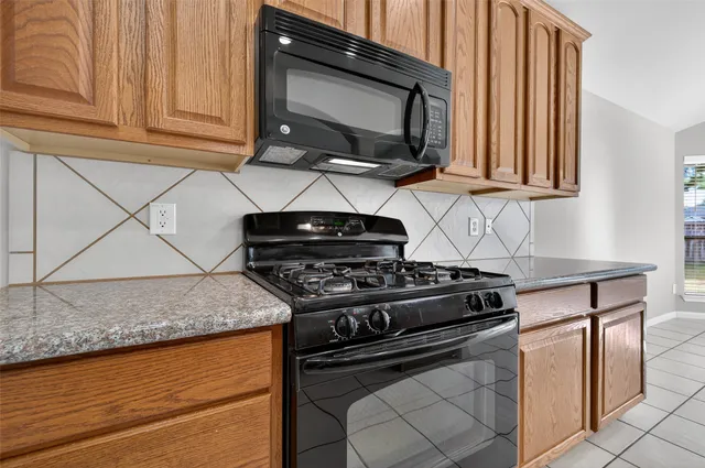 a kitchen with granite countertop stainless steel appliances sink and cabinets