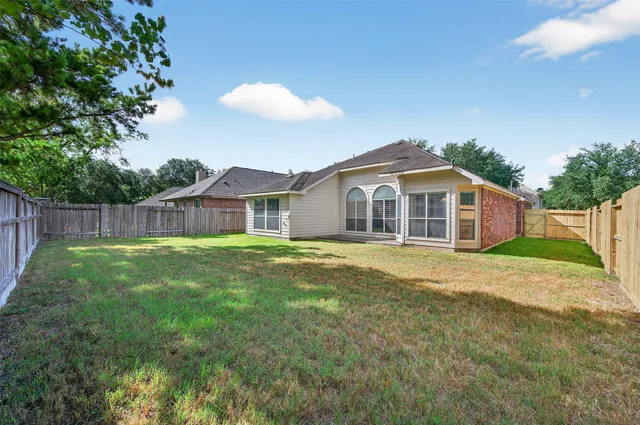 a view of a yard in front of a house with a large tree