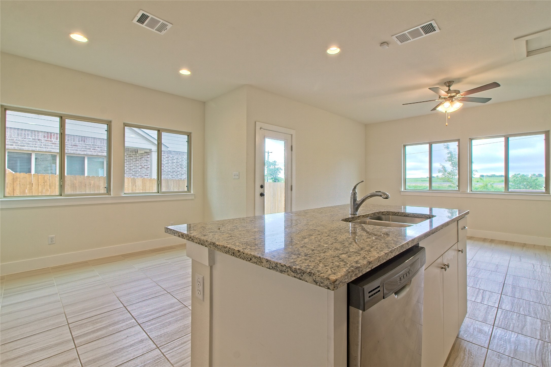 555 White Steppe Way Georgetown, TX 78626 - Photo 11 of 40 Kitchen with dishwasher, light stone countertops, a kitchen island with sink, ceiling fan, and recessed lighting