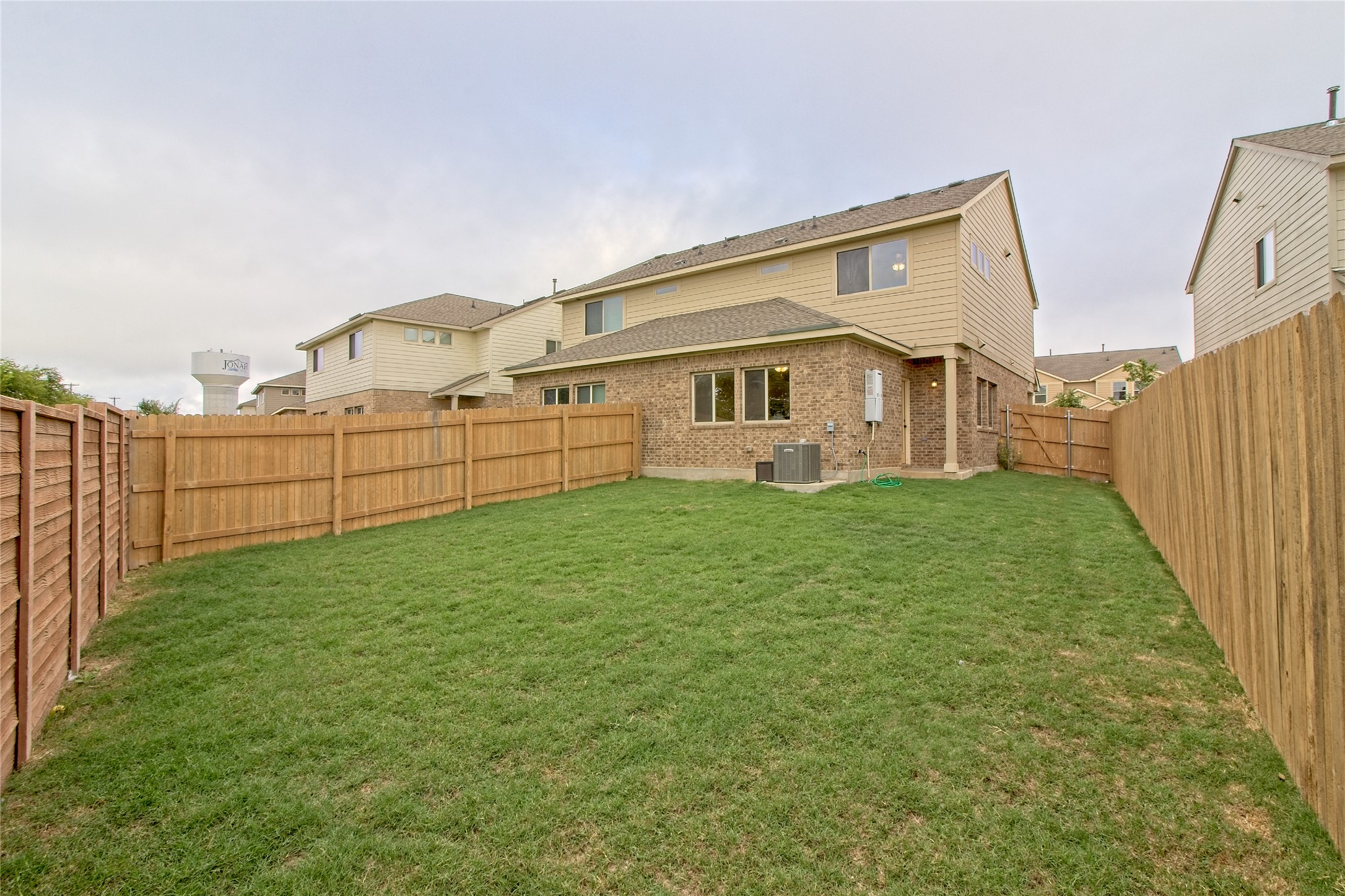 555 White Steppe Way Georgetown, TX 78626 - Photo 26 of 40 Rear view of house with a fenced backyard and brick siding