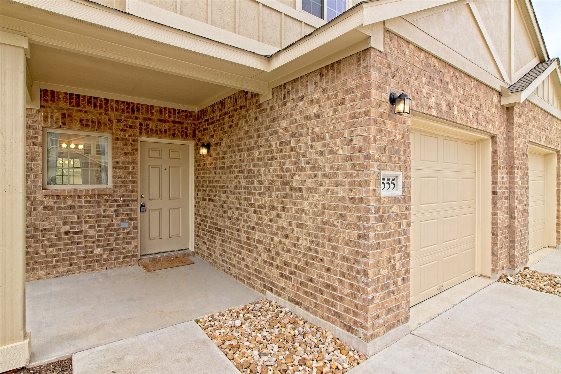 555 White Steppe Way Georgetown, TX 78626 - Photo 4 of 40 View of exterior entry featuring brick siding, board and batten siding, concrete driveway, and a garage