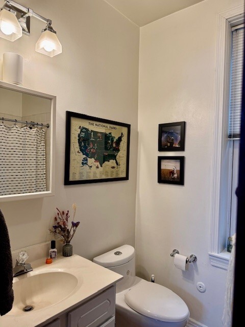 Undisclosed Address Chicago, IL 60614 - Photo 19 of 20 a bathroom with a toilet a sink and mirror